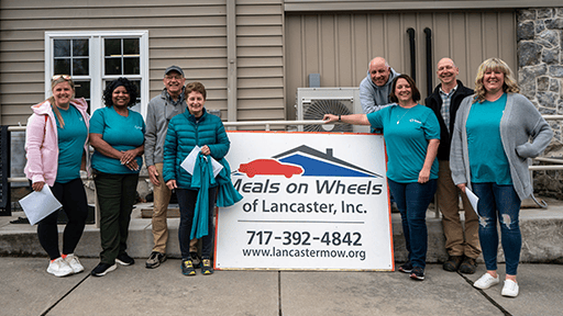 Penlanco volunteers standing in front of Meals on Wheels building.