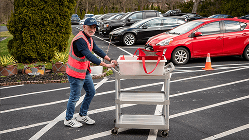 Elan volunteer running meals to waiting drivers.