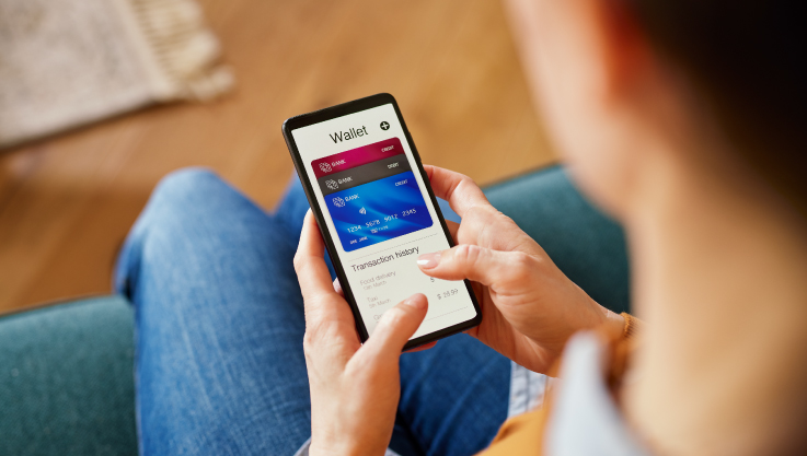 A person holds their phone. On the screen are three virtual cards.